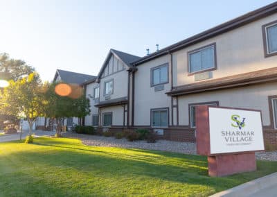 The exterior of a building with a sign out front and green grass